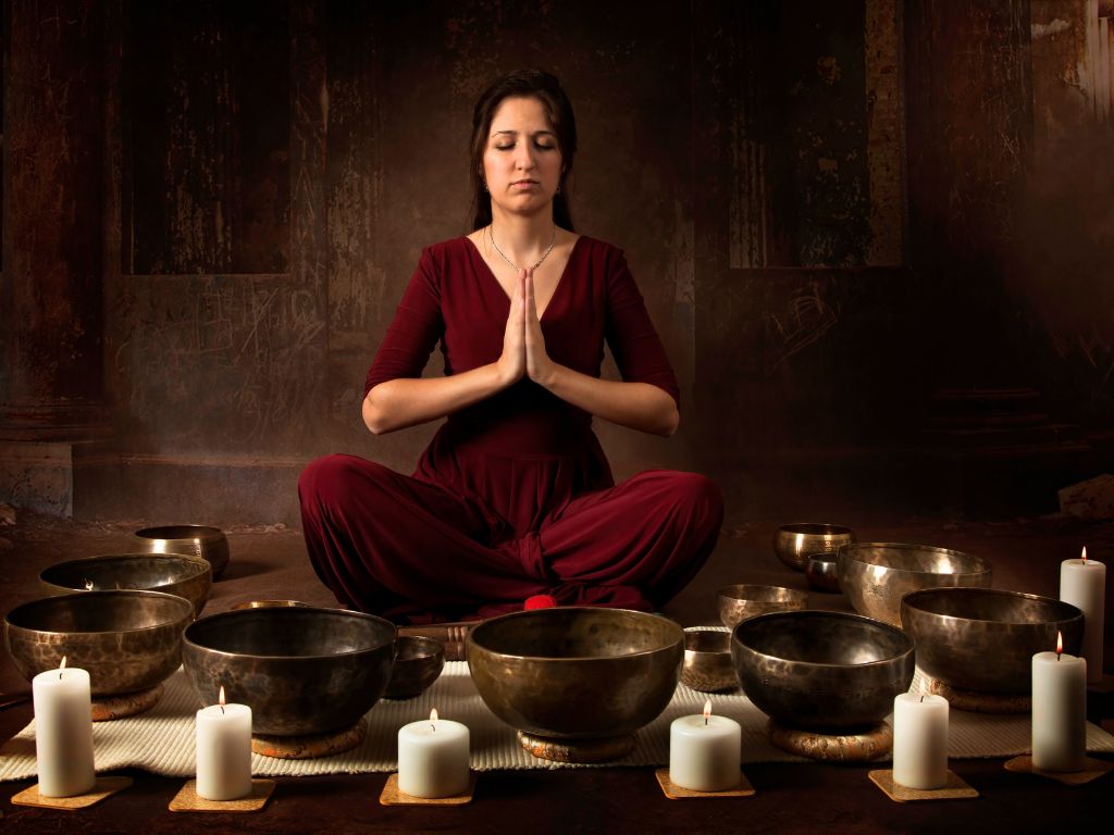 una donna pratica con ciotole tibetane