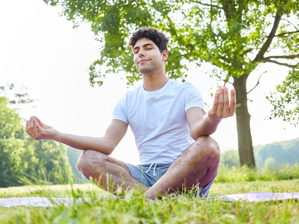 una ragazzo medita nella natura