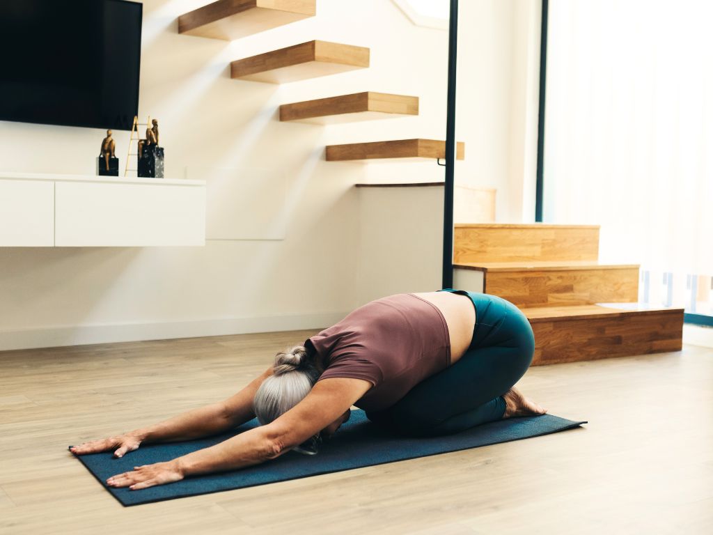 una donna in balasana, posizione del bambino