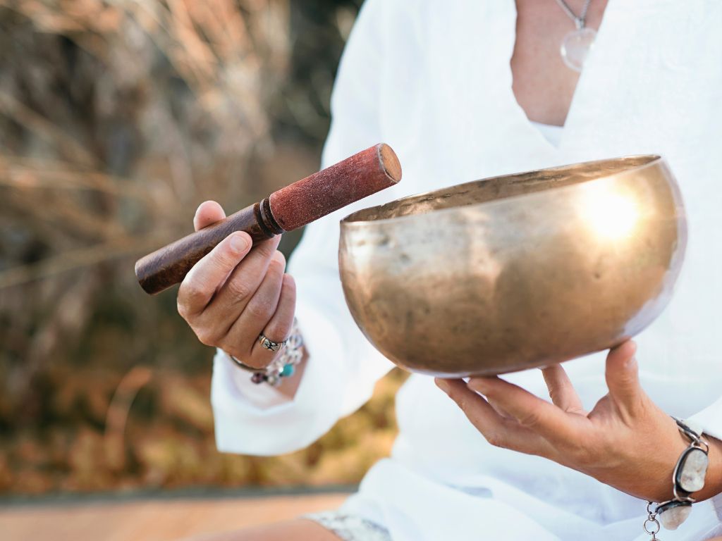 una donna suona la campana tibetana