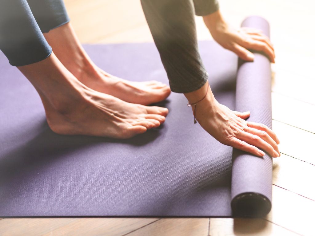 una-donna-srotola-tappetino-yoga-per-la-pratica