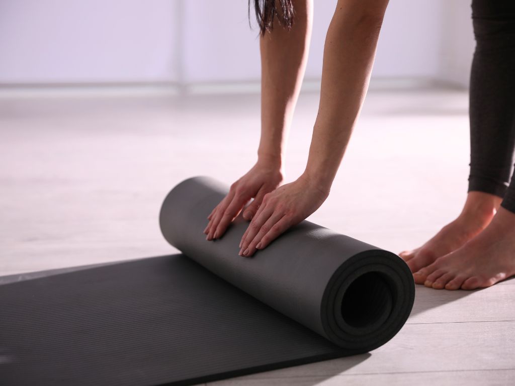 una-donna-srotola-tappetino-yoga-per-la-pratica